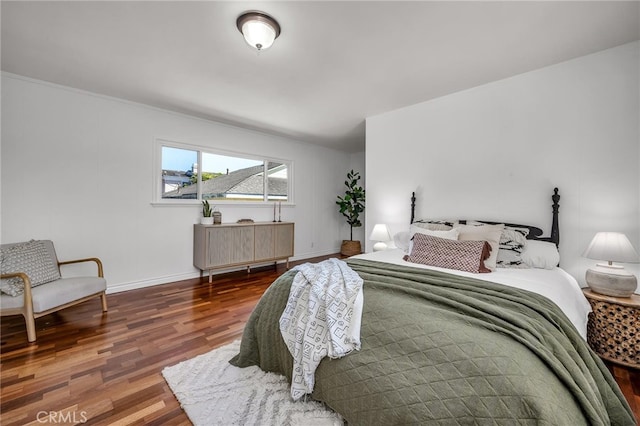 bedroom featuring baseboards and wood finished floors