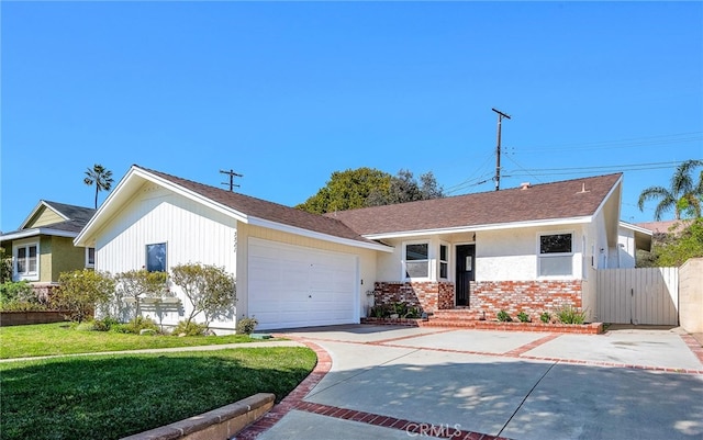 view of front of house with a garage, concrete driveway, fence, a front lawn, and brick siding