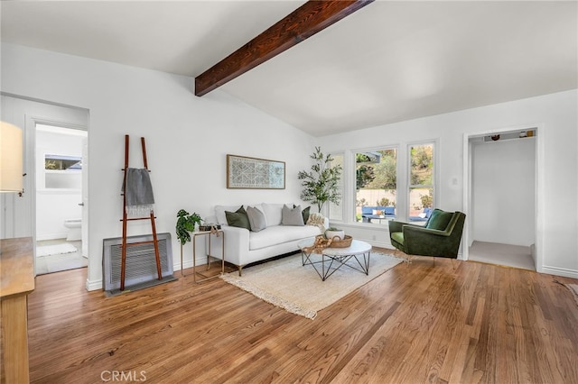 living room with vaulted ceiling with beams, wood finished floors, and baseboards