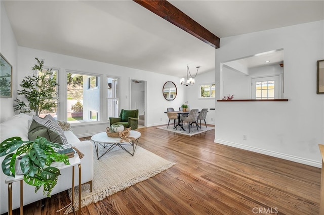 living room featuring vaulted ceiling with beams, a chandelier, wood finished floors, and baseboards