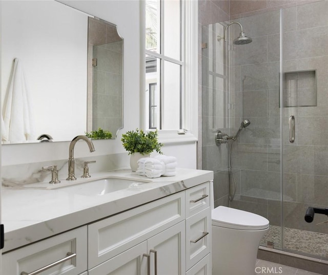 bathroom with toilet, a stall shower, and vanity