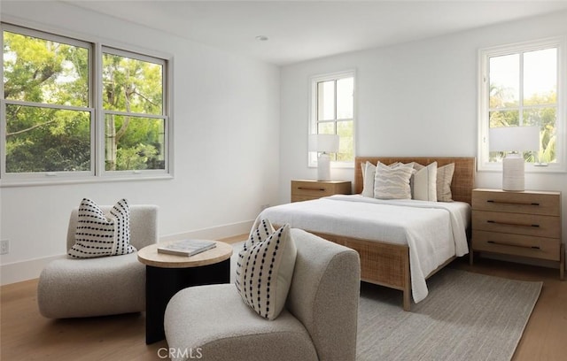 bedroom featuring wood finished floors and baseboards