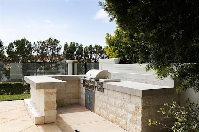 view of patio / terrace featuring a grill, an outdoor kitchen, and fence