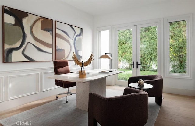 office area with a decorative wall, wood finished floors, and french doors