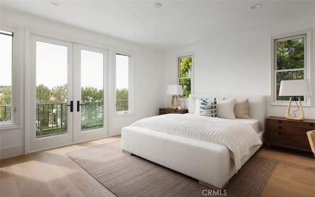 bedroom featuring access to exterior, light wood finished floors, and french doors