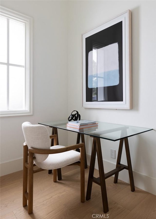 dining space featuring light wood-type flooring, baseboards, and breakfast area