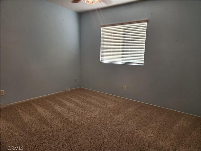 spare room featuring carpet flooring and a ceiling fan