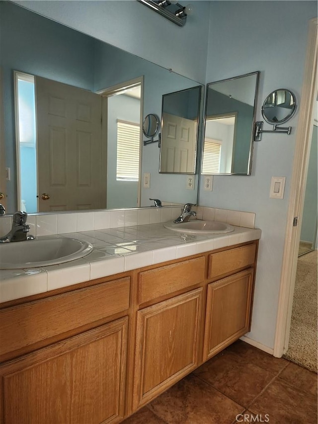 bathroom with double vanity, a sink, and tile patterned floors