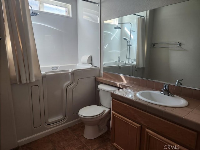 bathroom featuring toilet, tile patterned flooring, a shower, and vanity