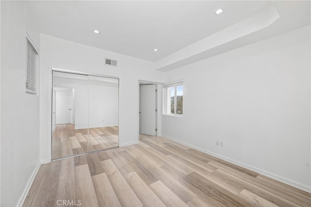 unfurnished bedroom with light wood-type flooring, visible vents, baseboards, and recessed lighting