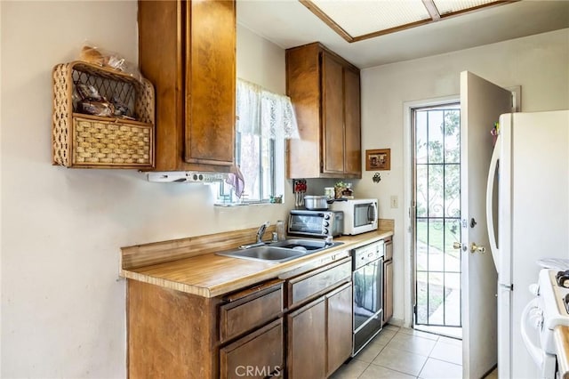 kitchen with light countertops, white appliances, a sink, and washer / dryer