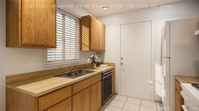 kitchen featuring light tile patterned floors, light countertops, freestanding refrigerator, a sink, and dishwashing machine