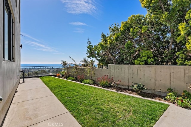 view of yard with a water view and a fenced backyard