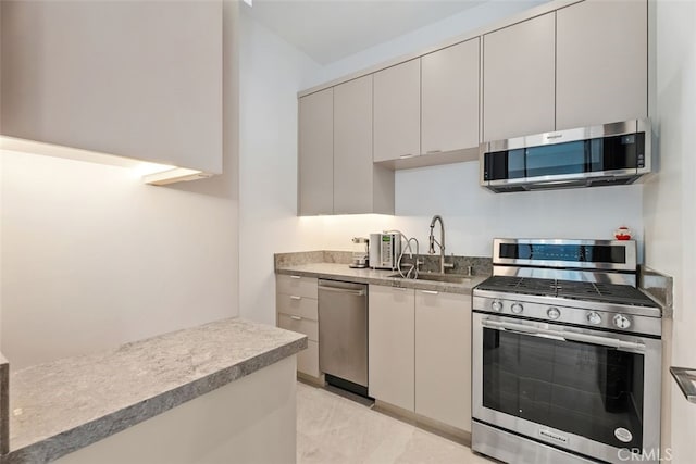 kitchen with modern cabinets, appliances with stainless steel finishes, and a sink