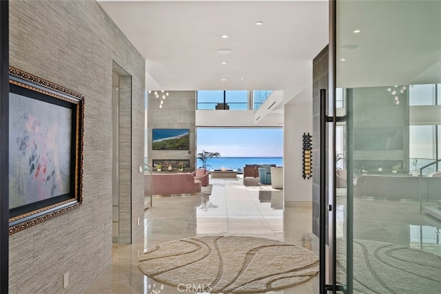 corridor featuring a towering ceiling and floor to ceiling windows