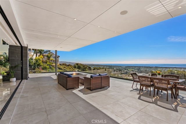 view of patio with outdoor dining space and an outdoor living space with a fire pit