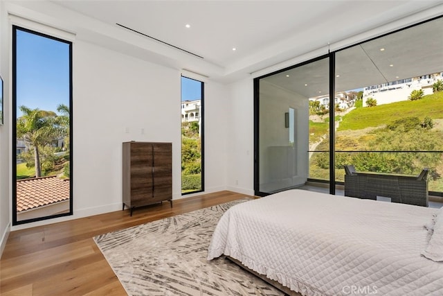 bedroom with recessed lighting, baseboards, and wood finished floors