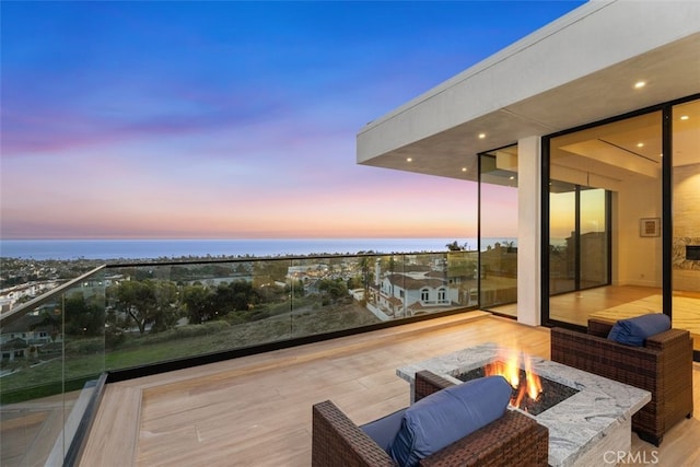 deck featuring a water view and a fire pit