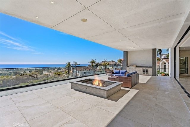 view of patio featuring a water view and an outdoor living space with a fire pit