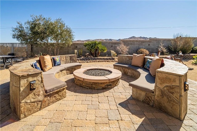 view of patio with a fenced backyard and an outdoor living space with a fire pit