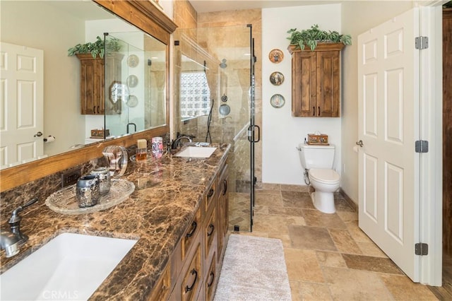 full bath featuring double vanity, a stall shower, a sink, and toilet