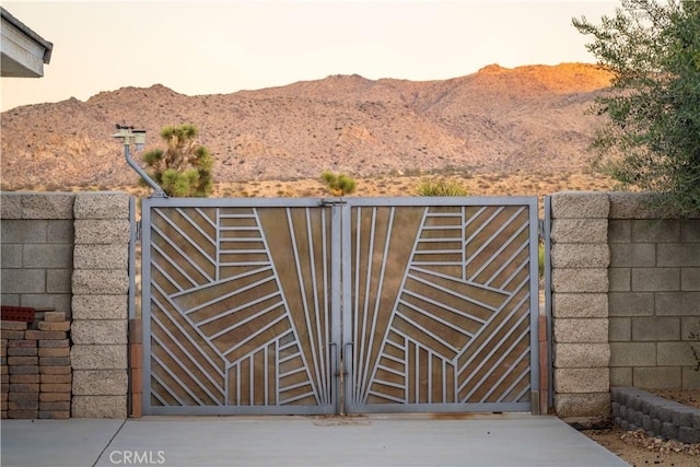 view of gate featuring fence and a mountain view