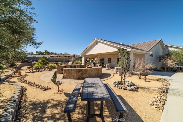 rear view of property featuring a tiled roof, a patio, and stucco siding