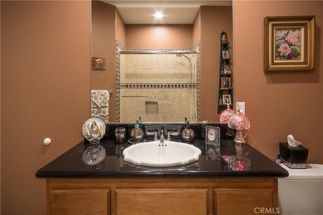 bathroom featuring tiled shower and vanity