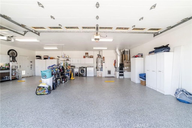 garage featuring a garage door opener, washing machine and dryer, and strapped water heater