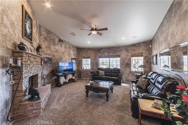 living room featuring carpet, visible vents, and a stone fireplace