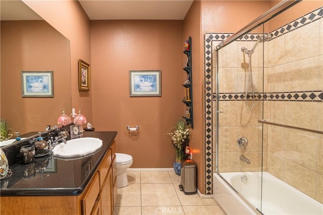 full bath featuring shower / bath combination with glass door, toilet, vanity, baseboards, and tile patterned floors