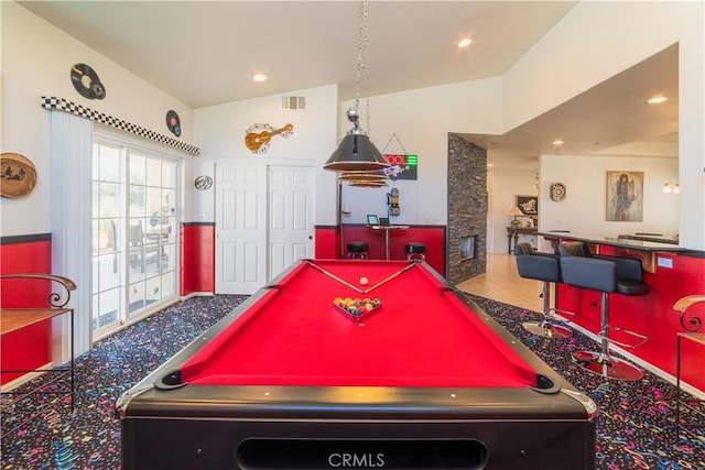 playroom featuring lofted ceiling, visible vents, a stone fireplace, and recessed lighting