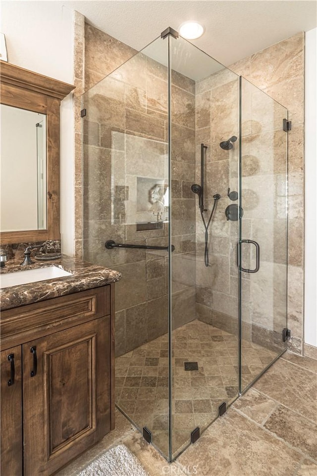 full bath with a shower stall and vanity