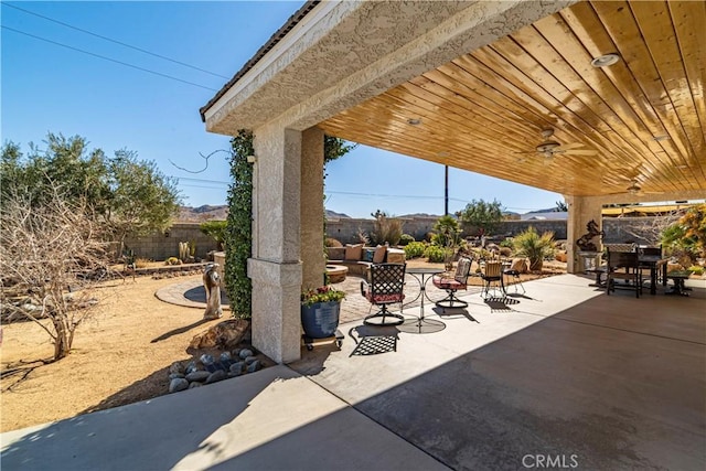 view of patio with outdoor dining area, a fenced backyard, and ceiling fan