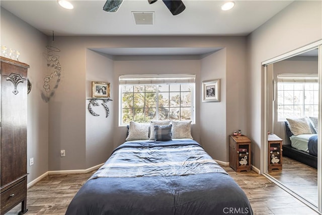 bedroom featuring multiple windows, wood finished floors, and visible vents