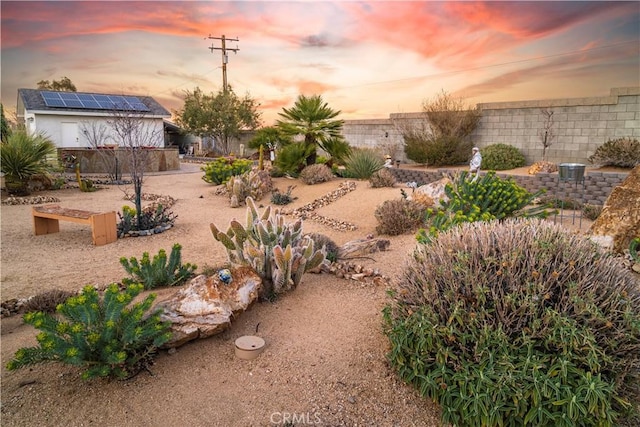 yard at dusk with a fenced backyard