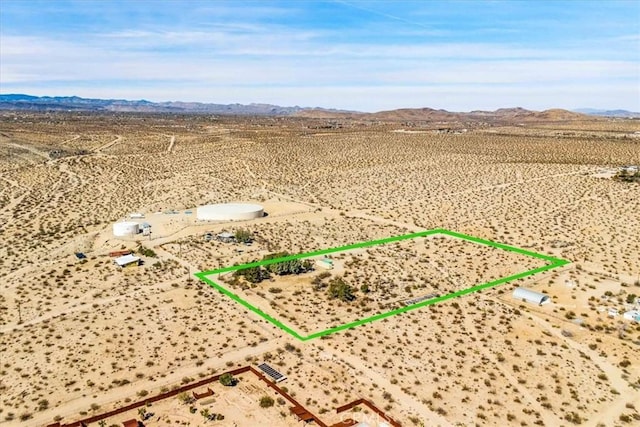 drone / aerial view featuring a desert view and a mountain view