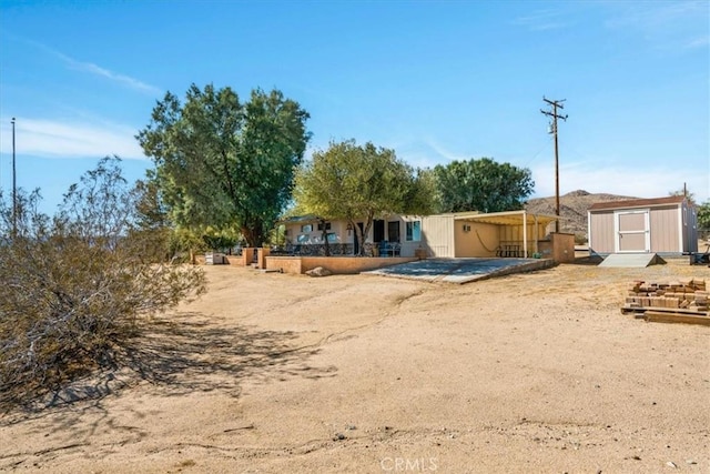 rear view of property featuring a shed and an outbuilding