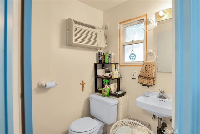 bathroom featuring a sink, toilet, and a wall mounted AC