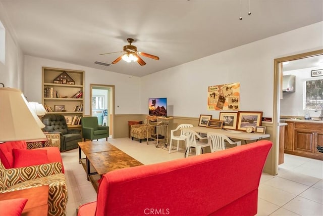 living area with light tile patterned flooring, ceiling fan, and visible vents