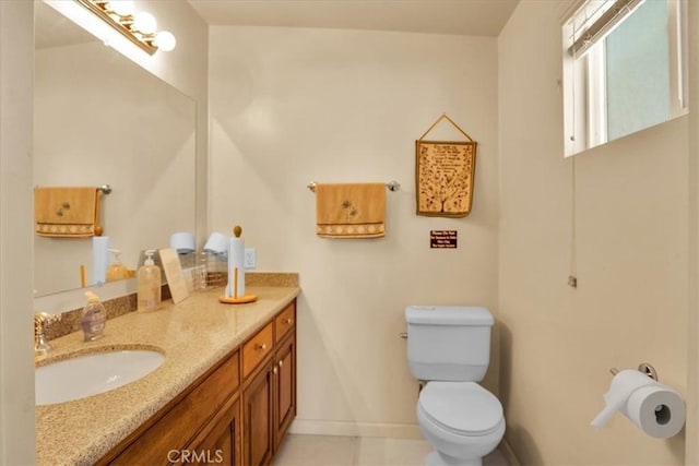 bathroom with tile patterned floors, vanity, toilet, and baseboards