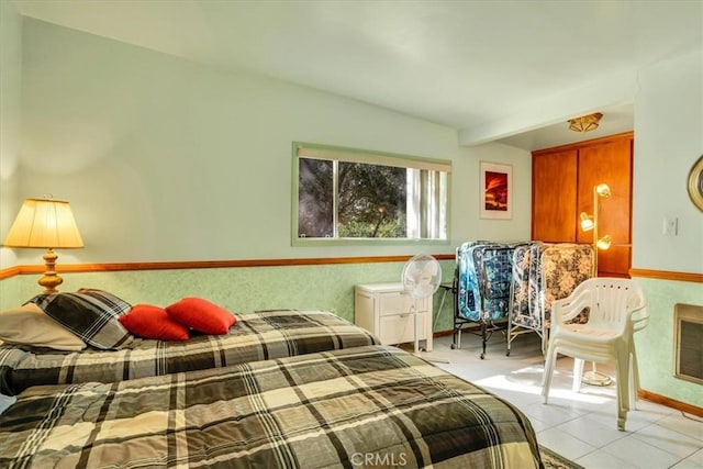 bedroom featuring light tile patterned floors, beam ceiling, and baseboards