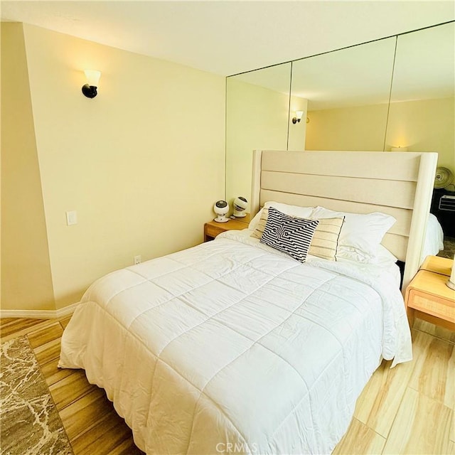 bedroom with baseboards and wood finished floors