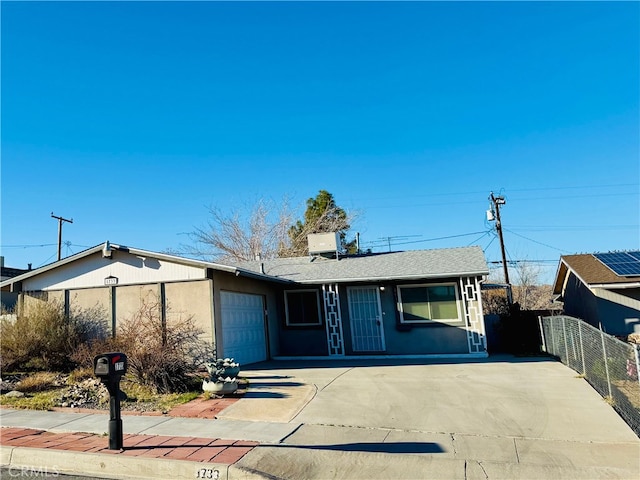 view of front of home with a garage, concrete driveway, fence, and stucco siding