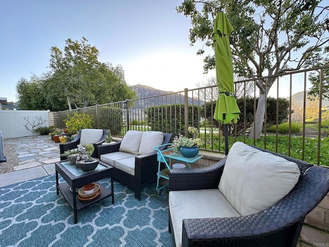 view of patio featuring an outdoor living space, a fenced backyard, and a mountain view