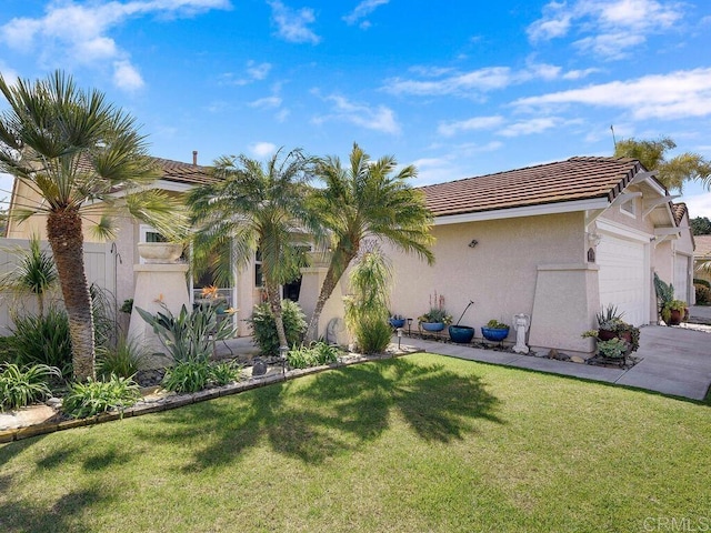 view of front of home featuring a tile roof, stucco siding, an attached garage, driveway, and a front lawn