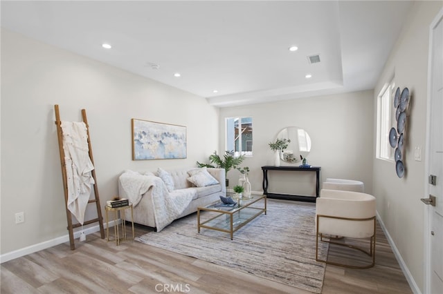 living room featuring visible vents, baseboards, wood finished floors, and recessed lighting