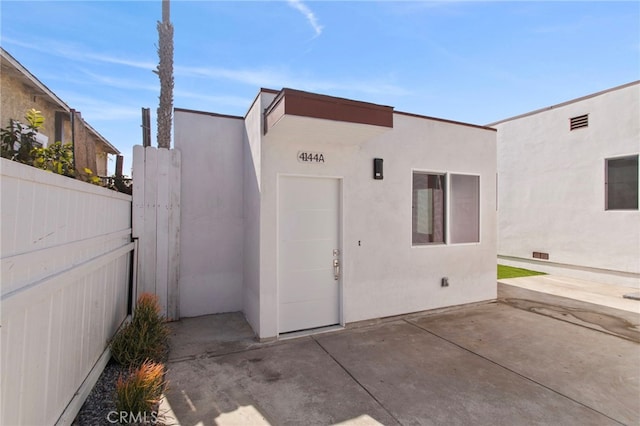 exterior space with visible vents, fence, a patio, and stucco siding