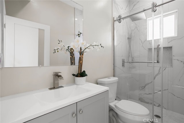 full bathroom featuring vanity, a marble finish shower, and toilet