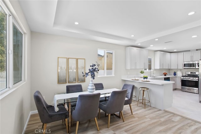 dining room featuring light wood-style floors, baseboards, and recessed lighting